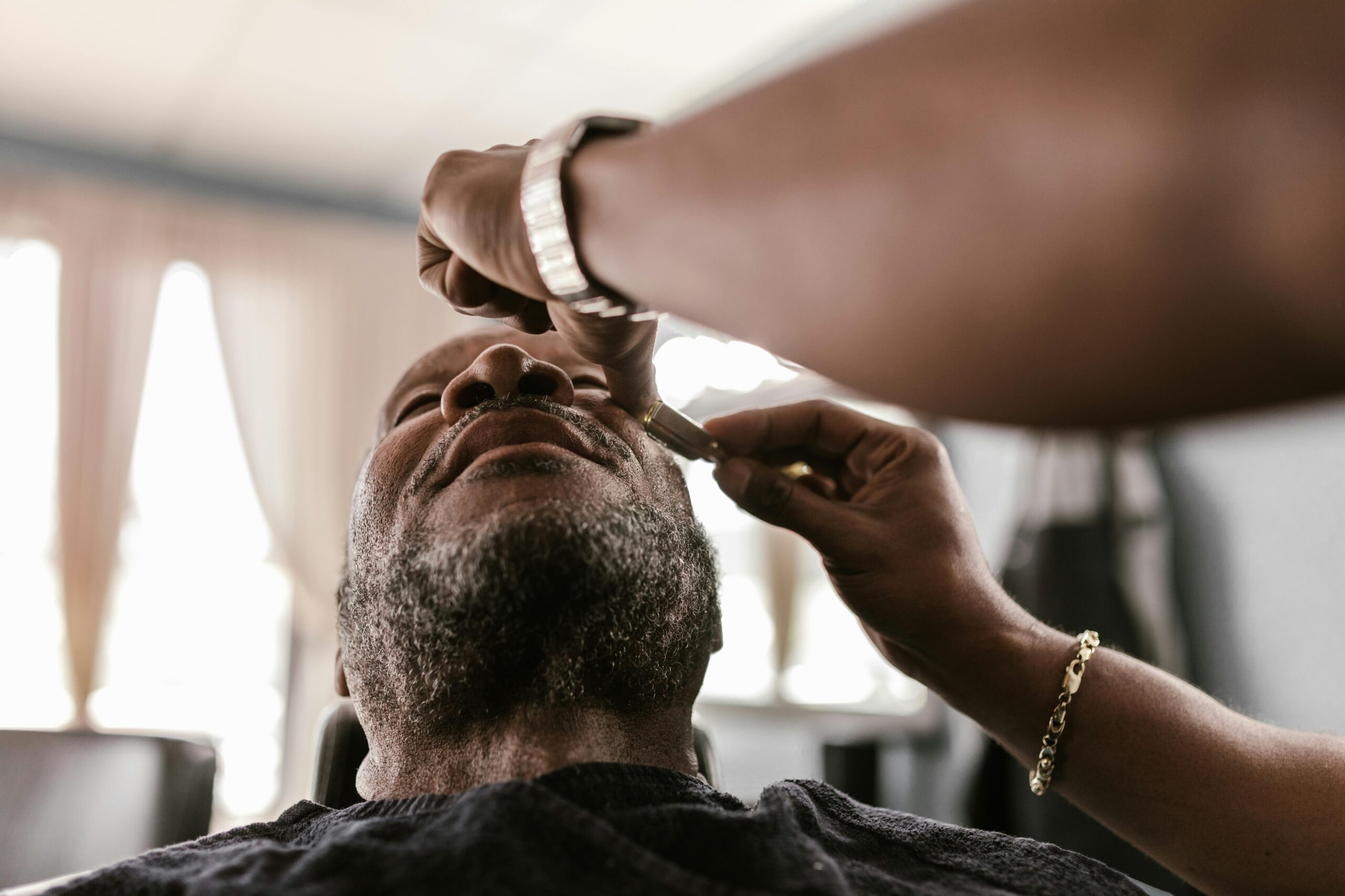pexels photo 7697668 7697668 A serene moment during a beard trim in a barbershop, featuring skilled hands and focused attention.